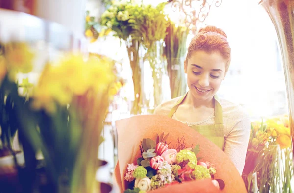 Fiorista sorridente donna con mazzo al negozio di fiori Immagine Stock