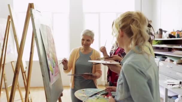 Mujeres con pinceles pintura en la escuela de arte — Vídeo de stock
