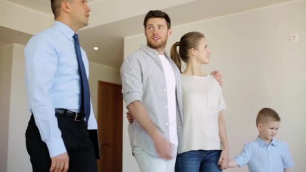 Família feliz e corretor de imóveis em casa nova ou apartamento — Vídeo de Stock