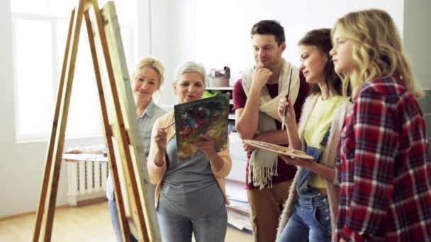 Группа художников обсуждающих живопись в художественной школе — стоковое видео