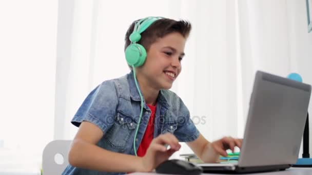 Jongen in hoofdtelefoon spelen video game op laptop — Stockvideo