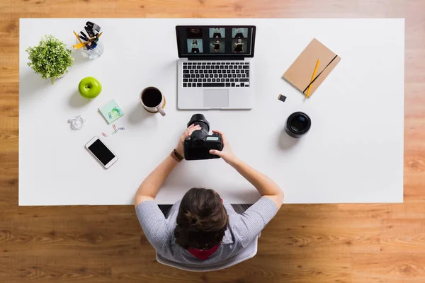 Mulher com câmera e laptop na mesa de escritório — Fotografia de Stock