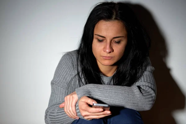 Unglücklich weinende Frau mit Smartphone — Stockfoto