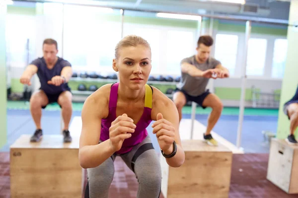 Gruppo di persone che fanno box salti esercizio in palestra — Foto Stock