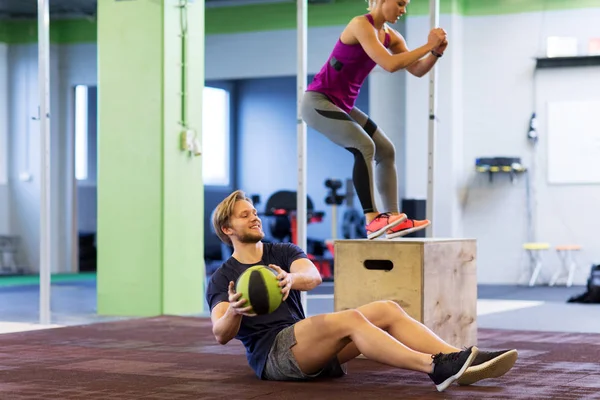 Mujer y hombre con balón de medicina haciendo ejercicio en el gimnasio — Foto de Stock