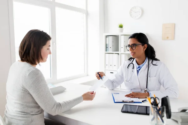 Arts met Klembord en vrouw patiënt bij kliniek — Stockfoto