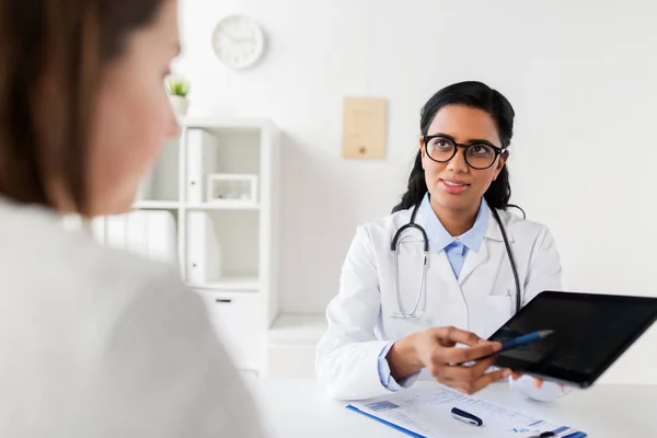 Médico com tablet pc e paciente mulher na clínica — Fotografia de Stock