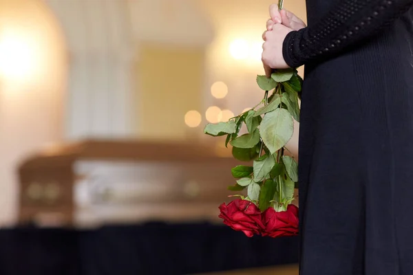 Primer plano de la mujer con rosas y ataúd en el funeral —  Fotos de Stock