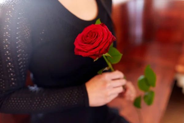 Primer plano de la mujer con rosas en el funeral en la iglesia — Foto de Stock