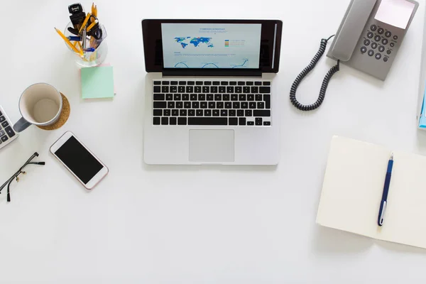 Laptop, telefoon en andere office-spullen op tafel — Stockfoto