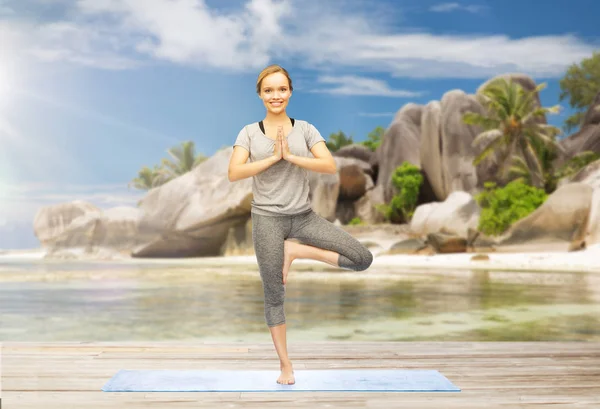 Frau macht Yoga in Baumpose im Freien am Strand — Stockfoto