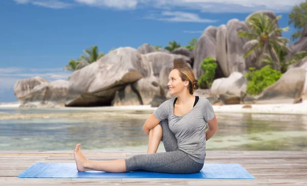 Žena, která dělá jógu v póze twist na pláži — Stock fotografie