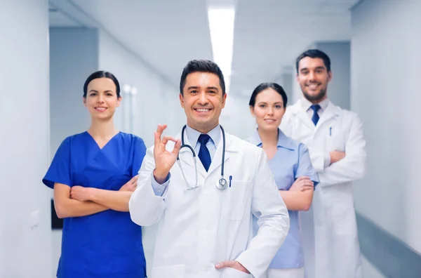 Groep van dokters in ziekenhuis weergegeven: ok hand teken — Stockfoto