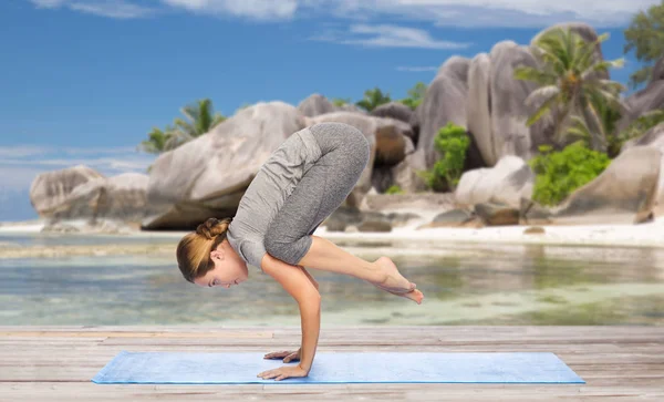 Frau macht Yoga in Kranichpose am Strand — Stockfoto