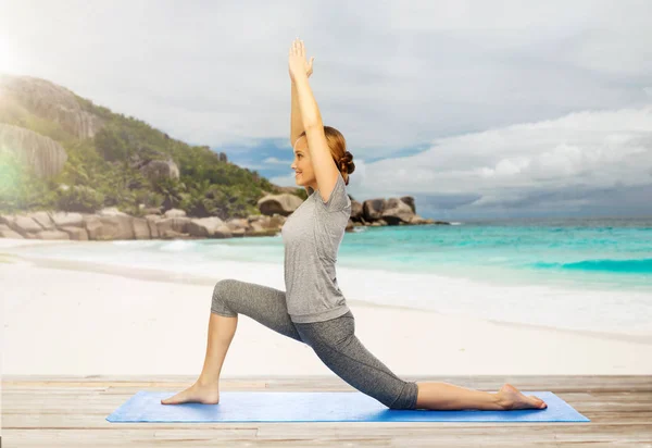 Glückliche Frau macht Yoga im niedrigen Ausfallschritt am Strand — Stockfoto