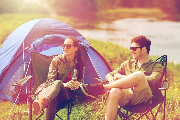 Feliz pareja bebiendo cerveza en la tienda del camping —  Fotos de Stock