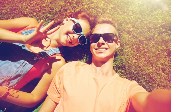 Mutlu genç çift alarak selfie yaz çimenlerin üzerinde — Stok fotoğraf