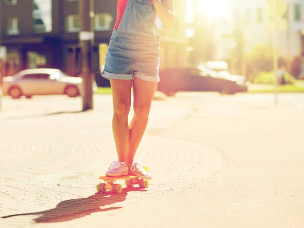 Teenage girl riding skateboard on city street — Stock Photo, Image