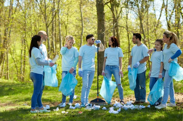 Kelompok relawan dengan kantong sampah di taman — Stok Foto