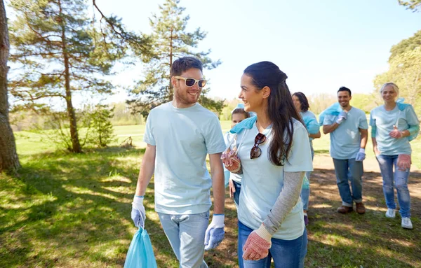 Volunteers with garbage bags talking outdoors — Stock Photo, Image