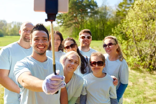 Grupp av frivilliga med smartphone selfie — Stockfoto