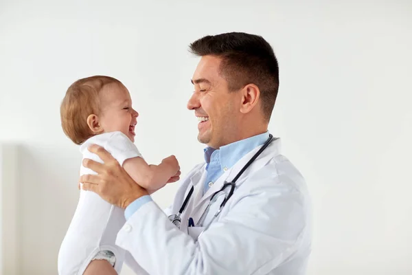 Gelukkig arts of kinderarts met baby bij kliniek — Stockfoto