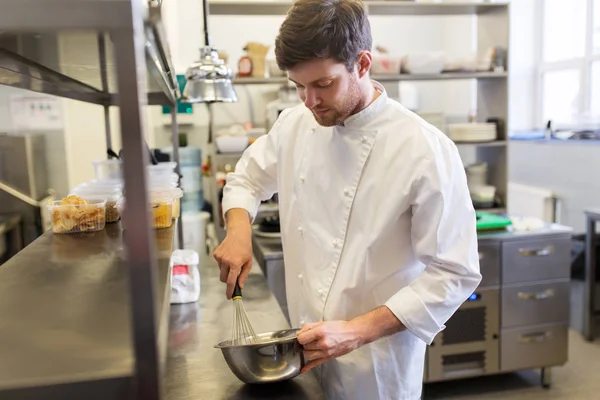 Glücklicher männlicher Koch kocht Essen in Restaurantküche lizenzfreie Stockfotos