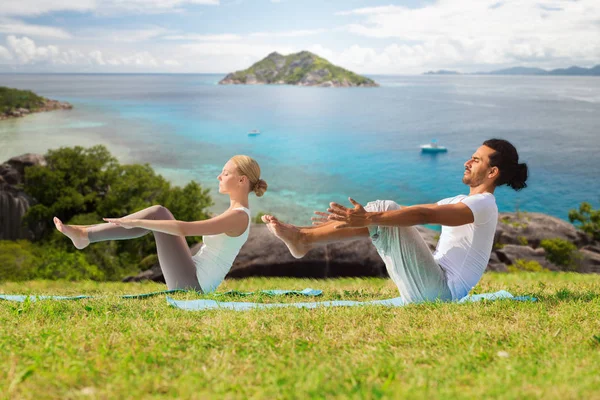 Pareja haciendo yoga media embarcación pose al aire libre —  Fotos de Stock