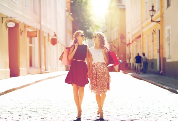 Mulheres felizes com sacos de compras andando na cidade — Fotografia de Stock