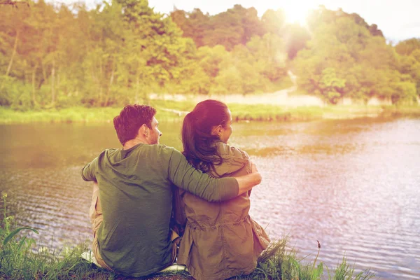 Feliz pareja abrazándose en el lago o la orilla del río — Foto de Stock