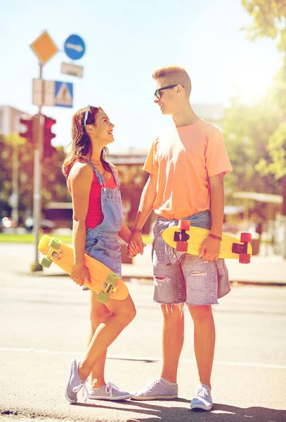 Teenage couple with skateboards on city street — Stock Photo, Image