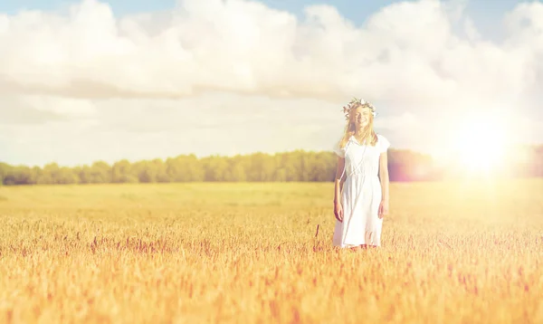 Felice giovane donna in corona di fiori sul campo di cereali — Foto Stock