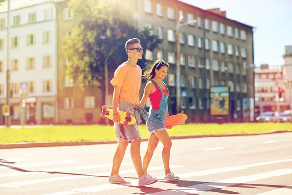 Teenage couple with skateboards on city street Royalty Free Stock Photos