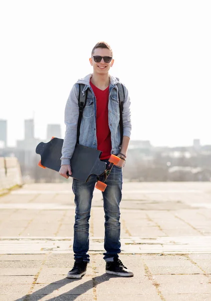 Happy young man or teenage boy with longboard — Stock Photo, Image