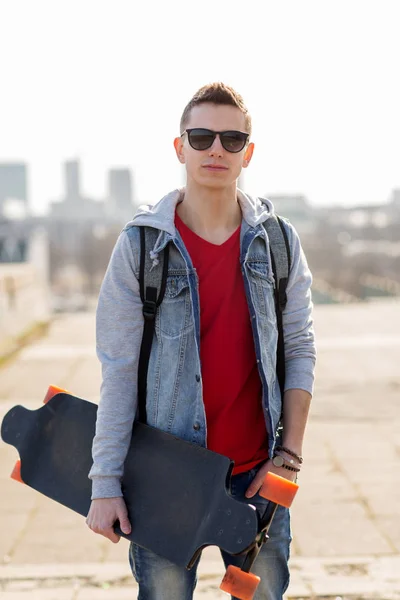 Happy young man or teenage boy with longboard — Stock Photo, Image