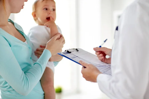 Woman, baby and doctor with clipboard at clinic — Stock Photo, Image