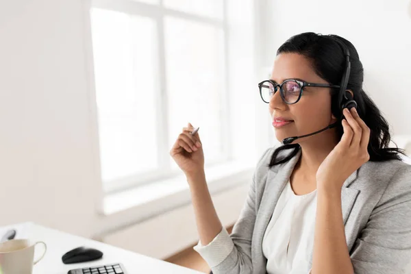 Geschäftsfrau mit Headset redet im Büro — Stockfoto