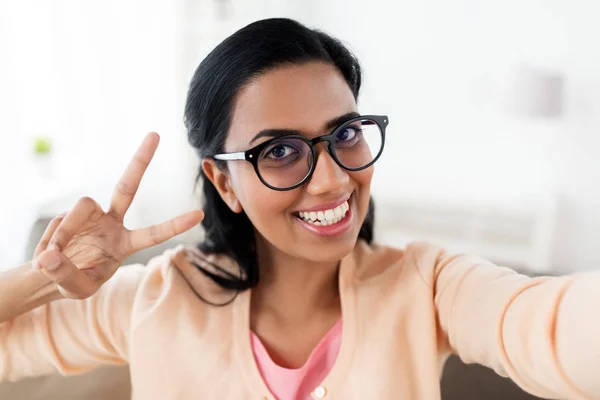 Sorrindo mulher tomando selfie e mostrando v sinal — Fotografia de Stock