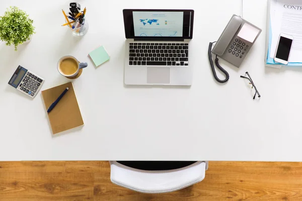 Laptop, telefoon en andere office-spullen op tafel — Stockfoto
