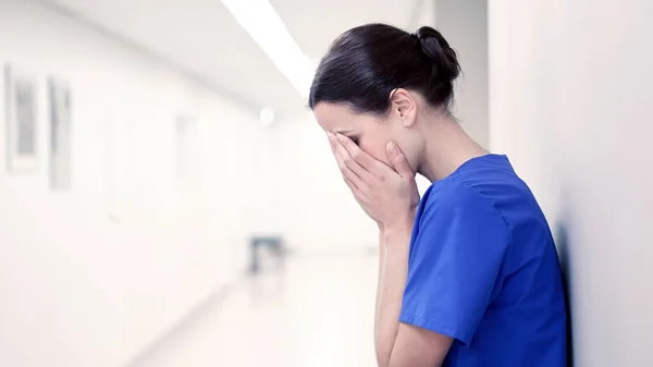 Enfermera triste o llorona en el pasillo del hospital —  Fotos de Stock