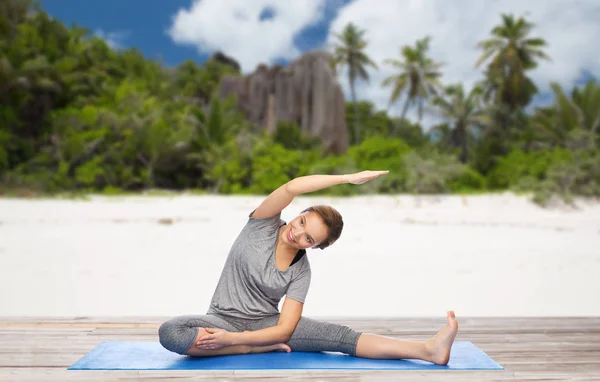 Donna felice facendo yoga e stretching sulla spiaggia — Foto Stock