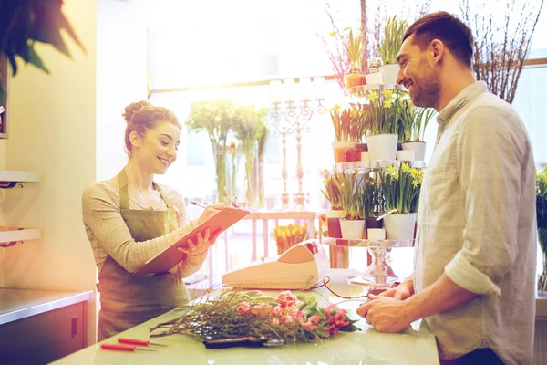 Floristería mujer y hombre haciendo orden en floristería — Foto de Stock