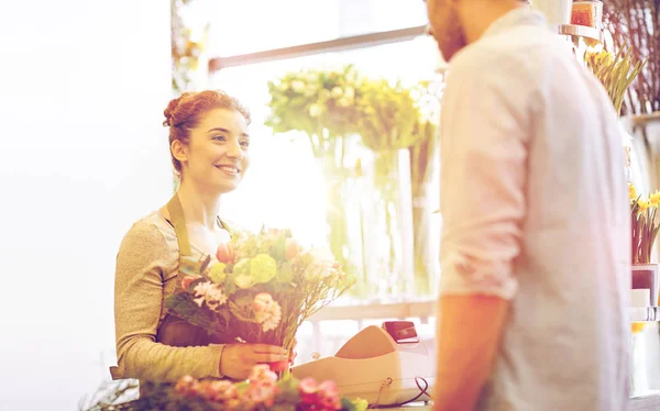 Fiorista sorridente donna e uomo al negozio di fiori — Foto Stock