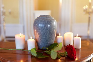 red rose and cremation urn with burning candles clipart