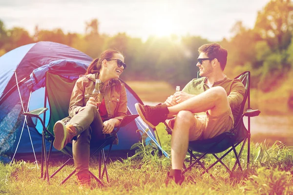 Coppia felice bere birra alla tenda del campeggio — Foto Stock