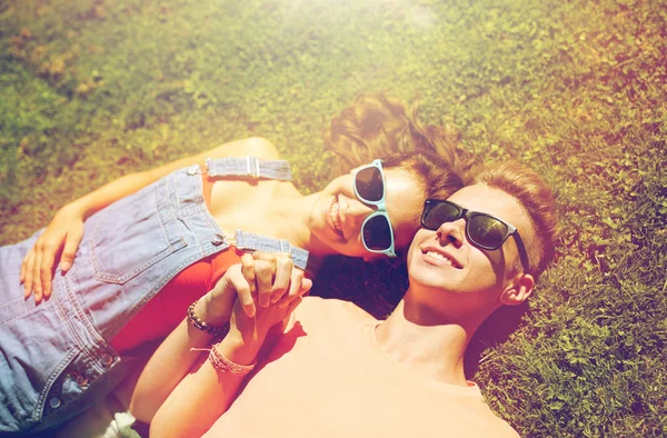 Feliz pareja adolescente acostada en la hierba en verano — Foto de Stock