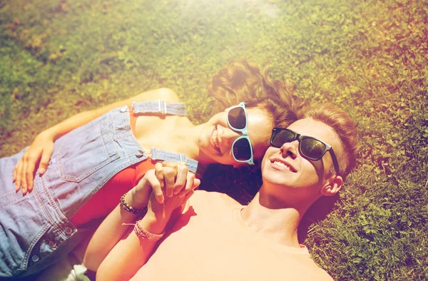 Glückliches Teenie-Paar liegt im Sommer im Gras — Stockfoto