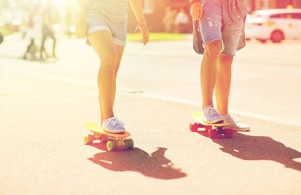 Pareja adolescente montando monopatines en la calle de la ciudad — Foto de Stock