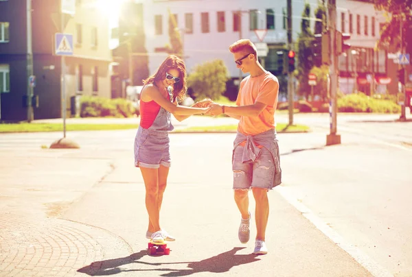 Tiener paar paardrijden skateboards op stad straat — Stockfoto