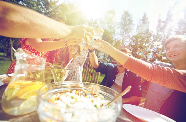 Счастливые друзья с напитками на вечеринке в летнем саду — стоковое фото